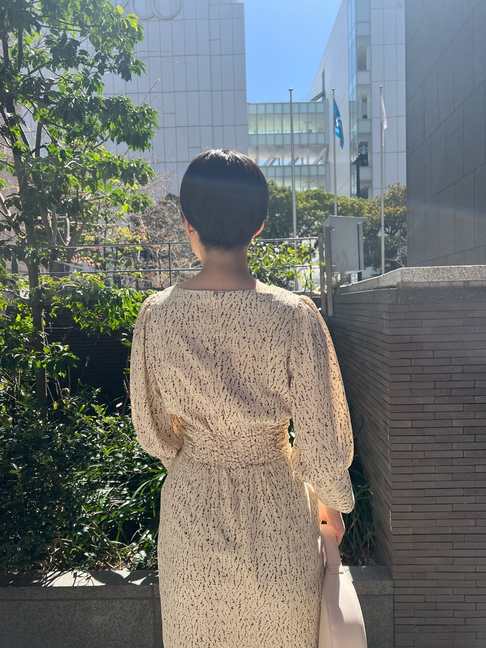 ホワイト系のハンドバッグ、ベージュ系のサンダル、ホワイト系のワンピースを着用したレディースの春コーディネートの8枚目の写真