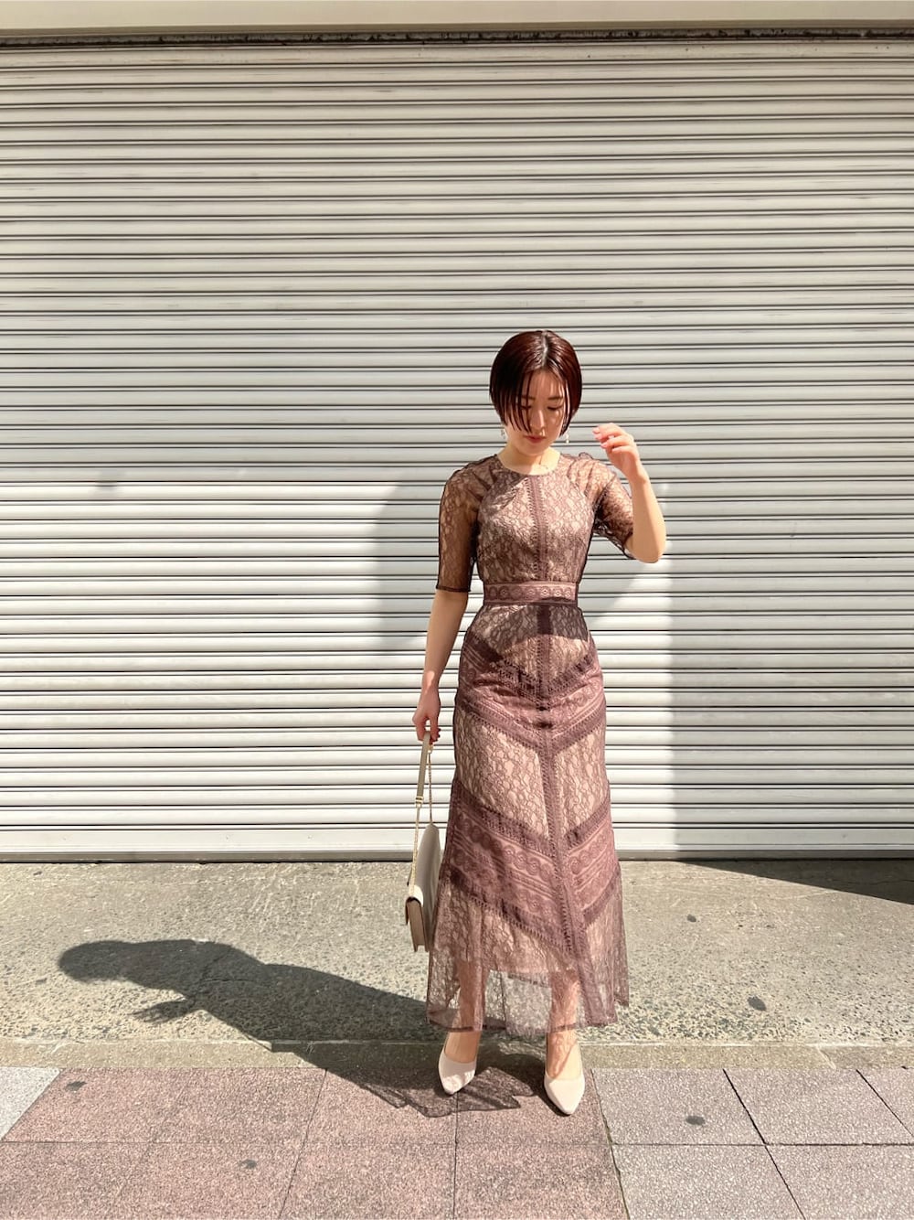 ホワイト系のノーカラーコート、ベージュ系のドレス、ベージュ系のパンプスを着用したレディースの春コーディネートの3枚目の写真