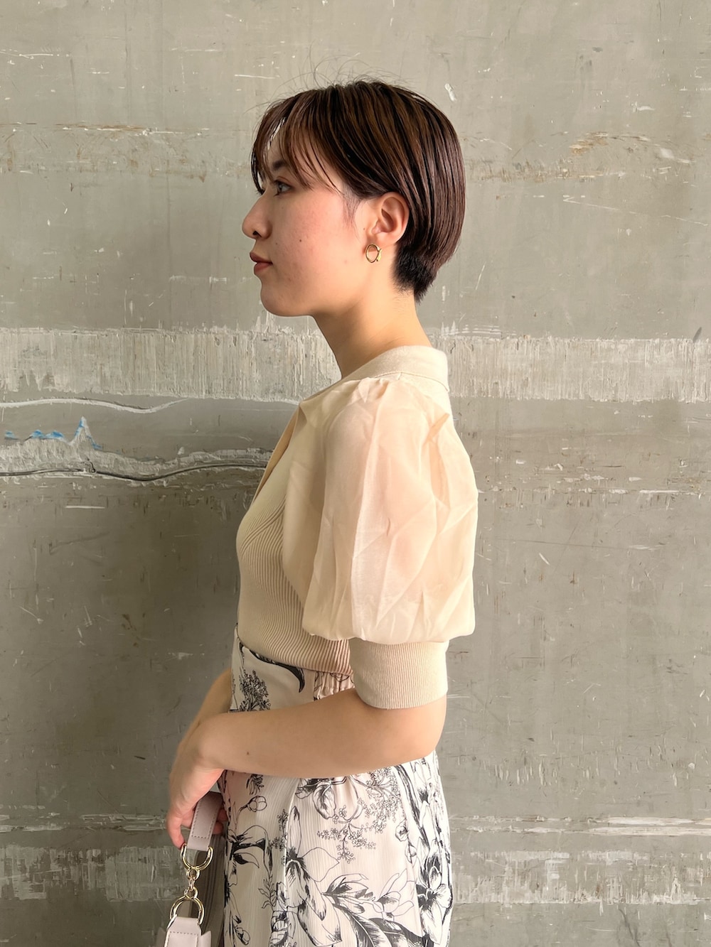 ホワイト系のニット/セーター、ホワイト系のスカート、ベージュ系のサンダルを着用したレディースの夏コーディネートの5枚目の写真