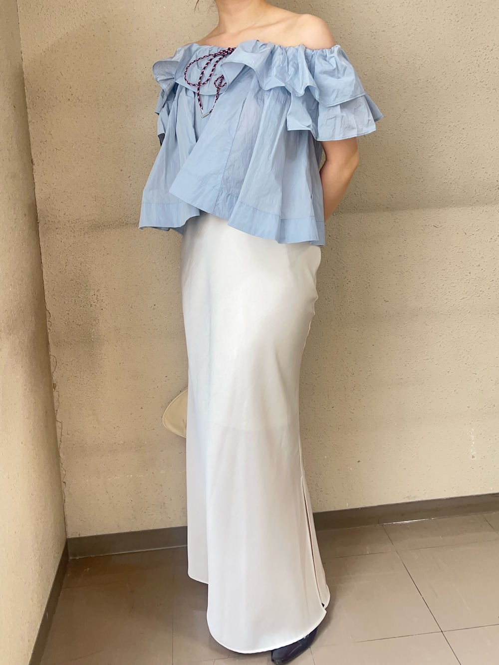 ブルー系のシャツ/ブラウス、ホワイト系のスカート、ブラック系のパンプスを着用したレディースの春コーディネートの4枚目の写真