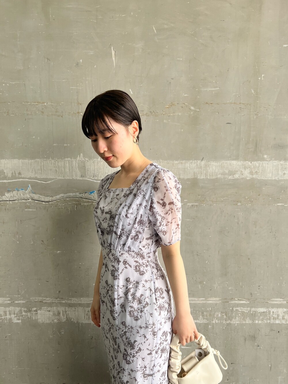 ベージュ系のサンダル、パープル系のワンピース、ホワイト系のハンドバッグを着用したレディースの春コーディネートの3枚目の写真