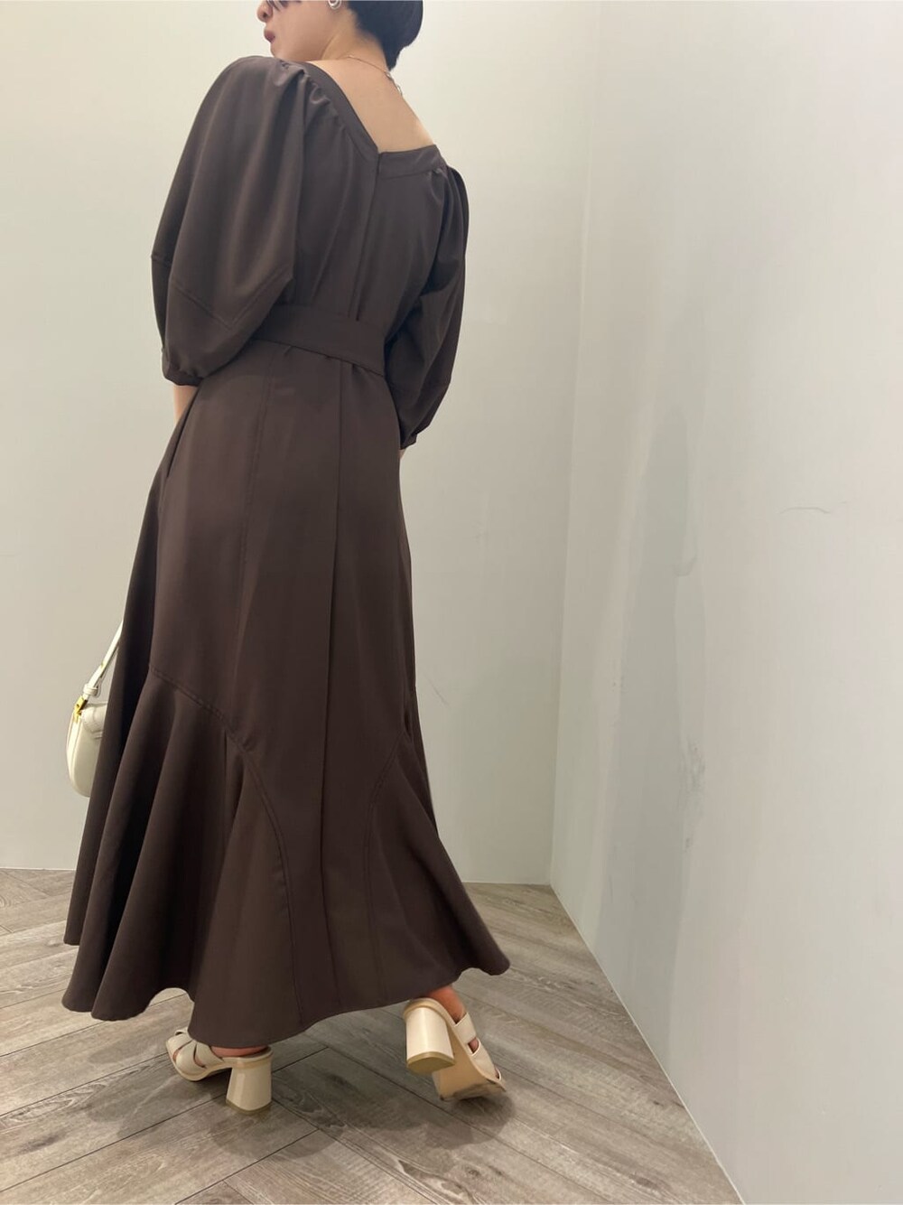 ホワイト系のサンダル、ブラウン系のワンピース、ホワイト系のショルダーバッグを着用したレディースの夏コーディネートの8枚目の写真