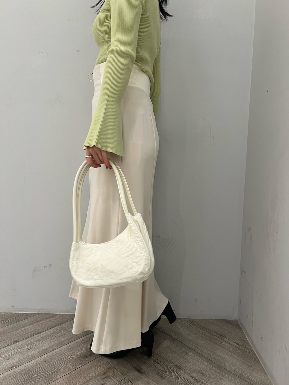 グリーン系のニット/セーター、ホワイト系のスカートを着用したレディースの冬コーディネートの9枚目の写真