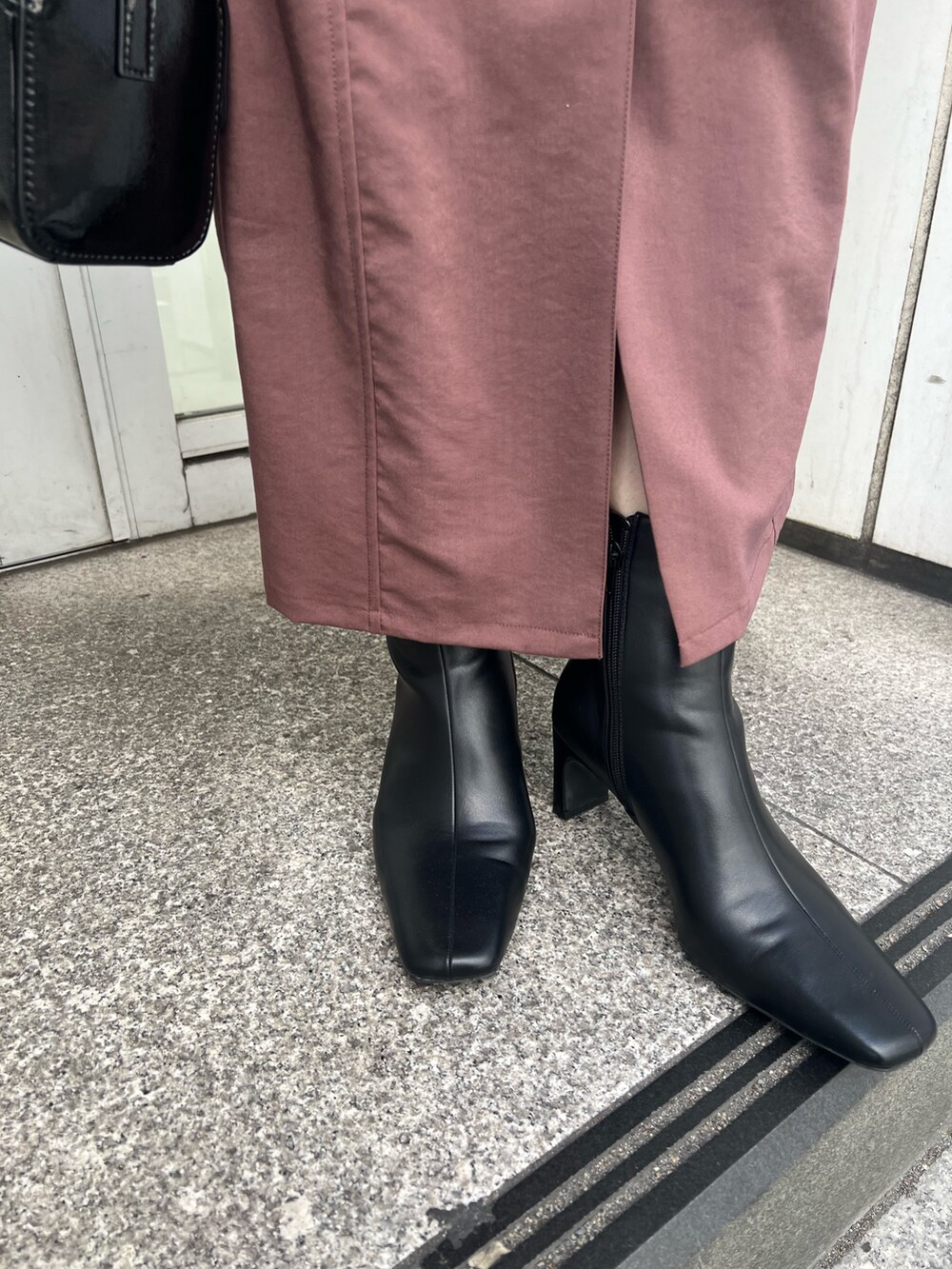 ブラック系のショルダーバッグ、ブラウン系のワンピース、ブラック系のブーツを着用したレディースの秋コーディネートの8枚目の写真