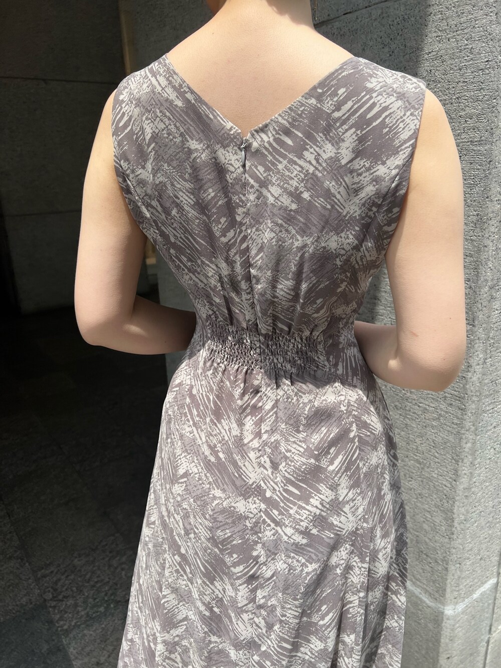 ホワイト系のハンドバッグ、ベージュ系のサンダル、グレー系のワンピースを着用したレディースの夏コーディネートの10枚目の写真