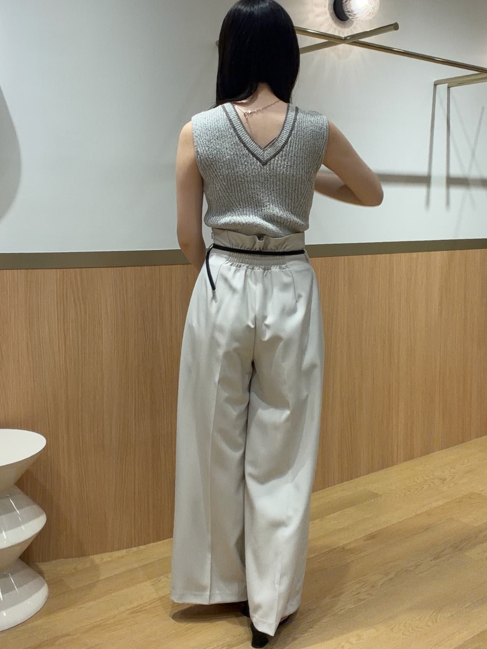 ベージュ系のニット/セーター、ホワイト系のその他パンツ、ブラック系のサンダルを着用したレディースの春コーディネートの2枚目の写真