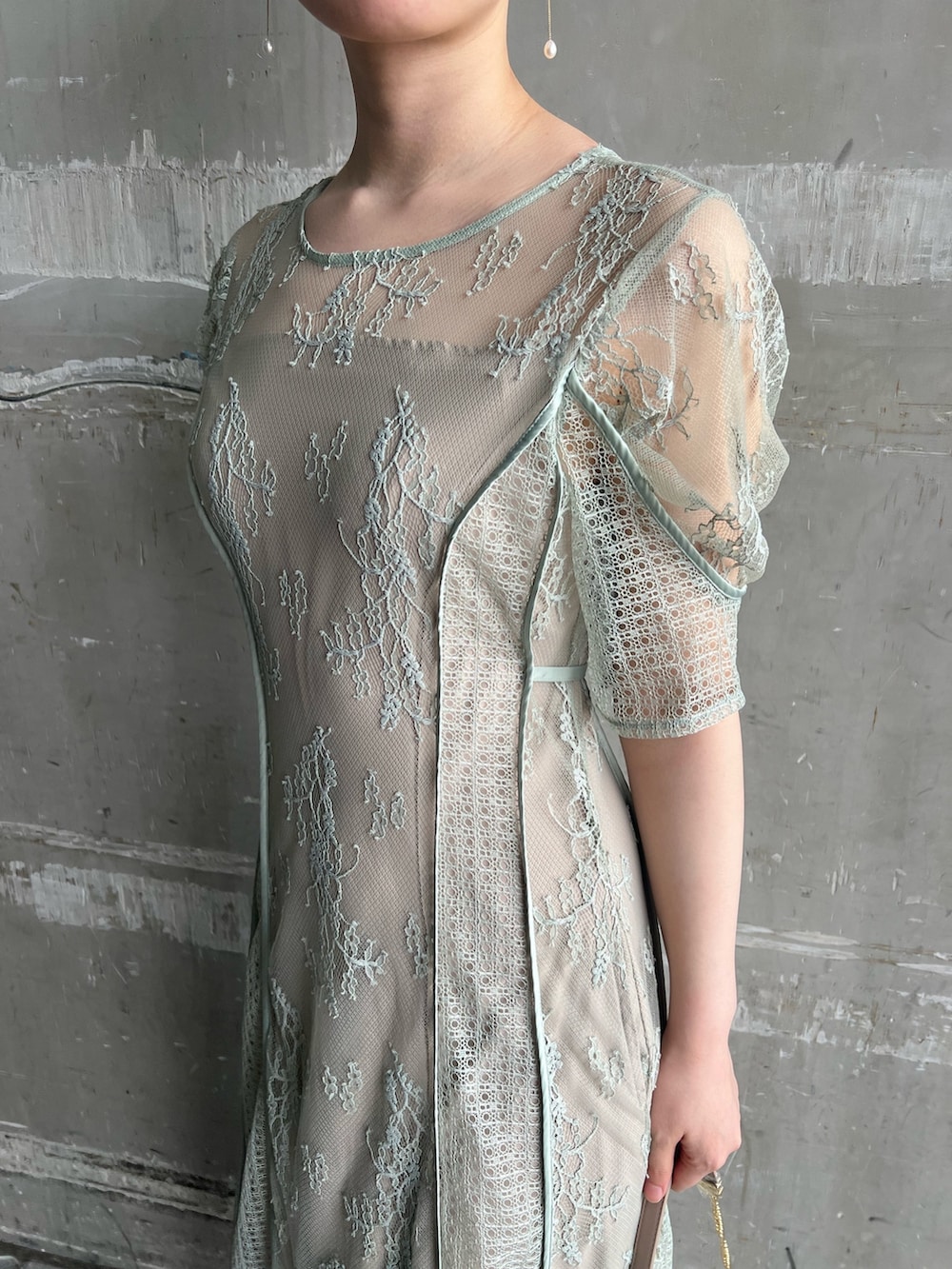 グリーン系のドレス、ベージュ系のパンプス、ベージュ系のクラッチバッグを着用したレディースの春コーディネートの4枚目の写真