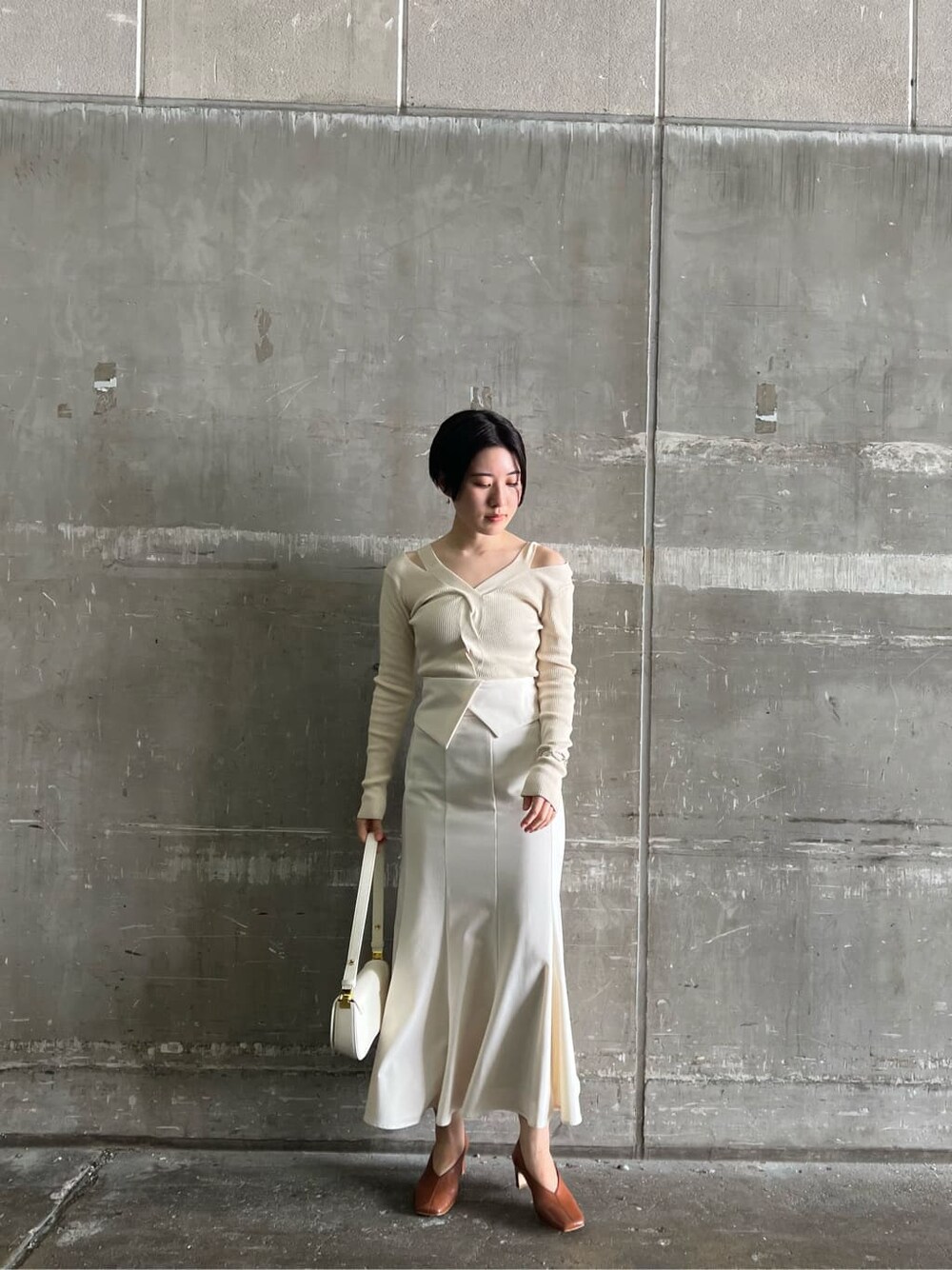 ブラウン系のパンプス、ホワイト系のスカート、ホワイト系のニット/セーターを着用したレディースの夏コーディネートの3枚目の写真
