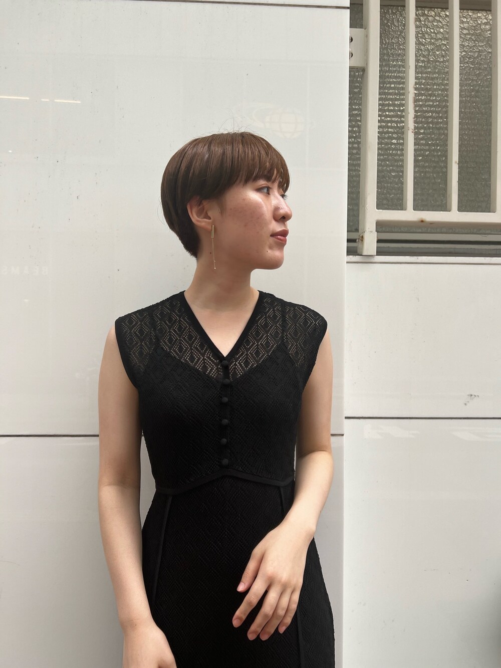 ベージュ系のサンダル、ホワイト系のハンドバッグ、ブラック系のワンピースを着用したレディースの夏コーディネートの3枚目の写真