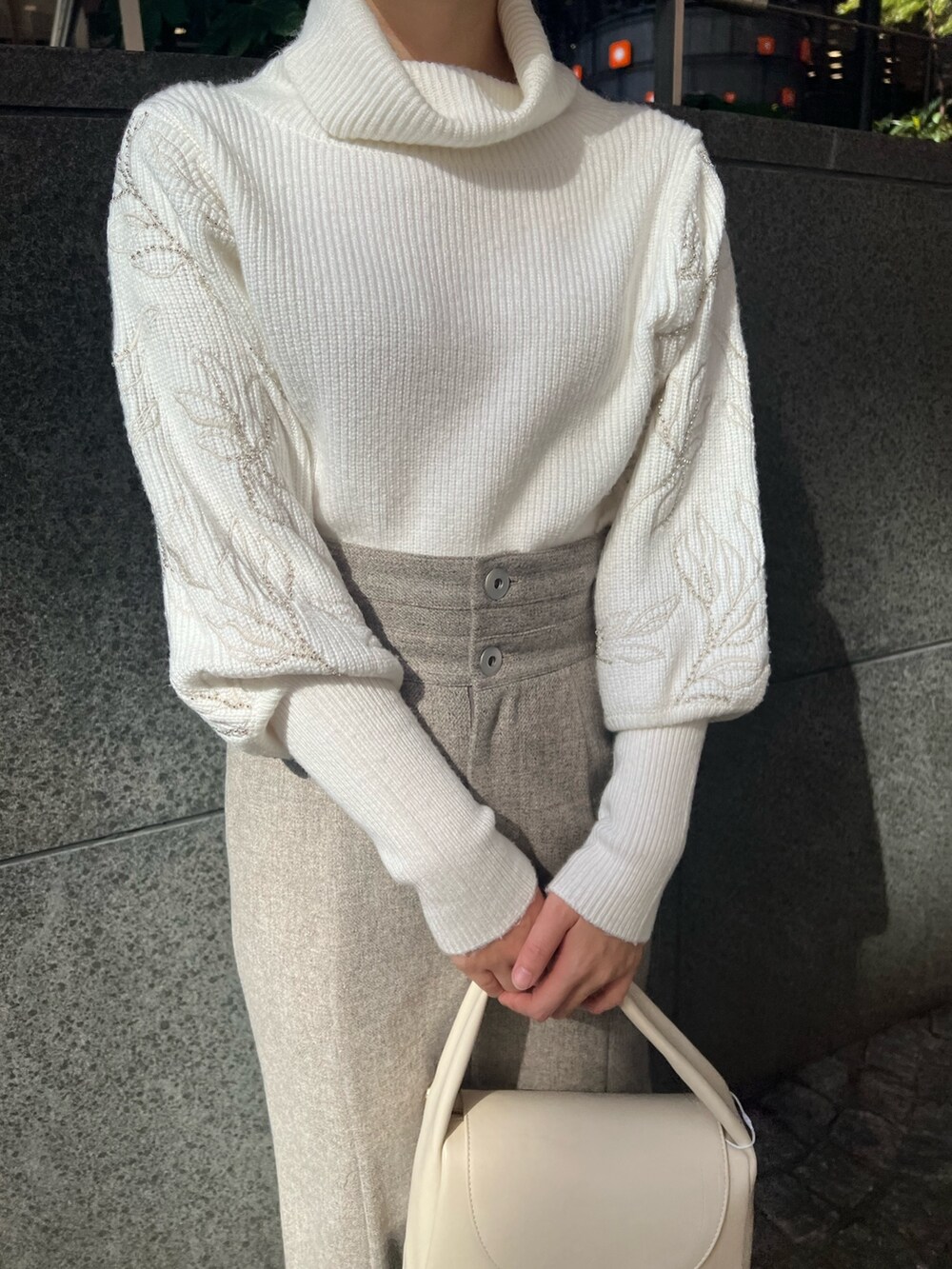 ベージュ系のブーツ、グレー系のスカート、ホワイト系のハンドバッグを着用したレディースの秋コーディネートの8枚目の写真