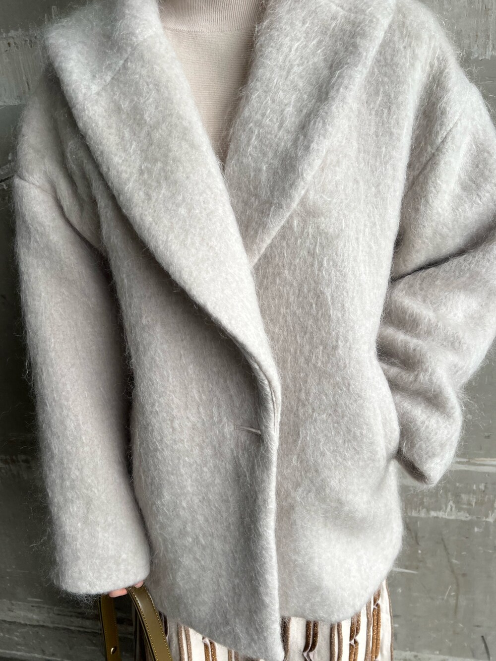 ブラウン系のショルダーバッグ、ベージュ系のブーツ、グレー系のその他アウターを着用したレディースの冬コーディネートの5枚目の写真