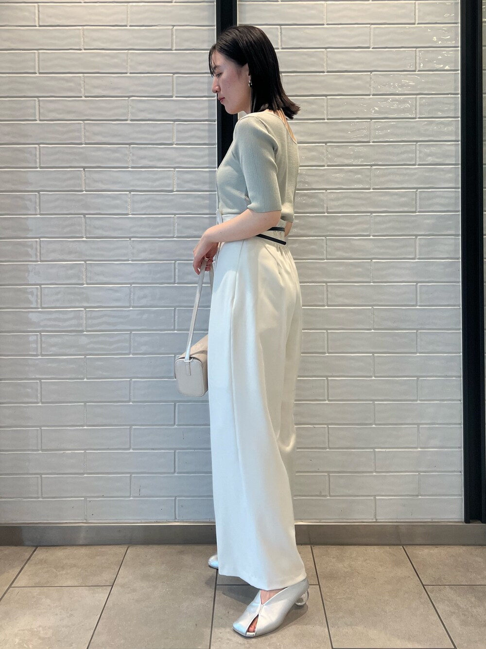 シルバー系のパンプス、グリーン系のニット/セーター、ホワイト系のその他パンツを着用したレディースの秋コーディネートの2枚目の写真