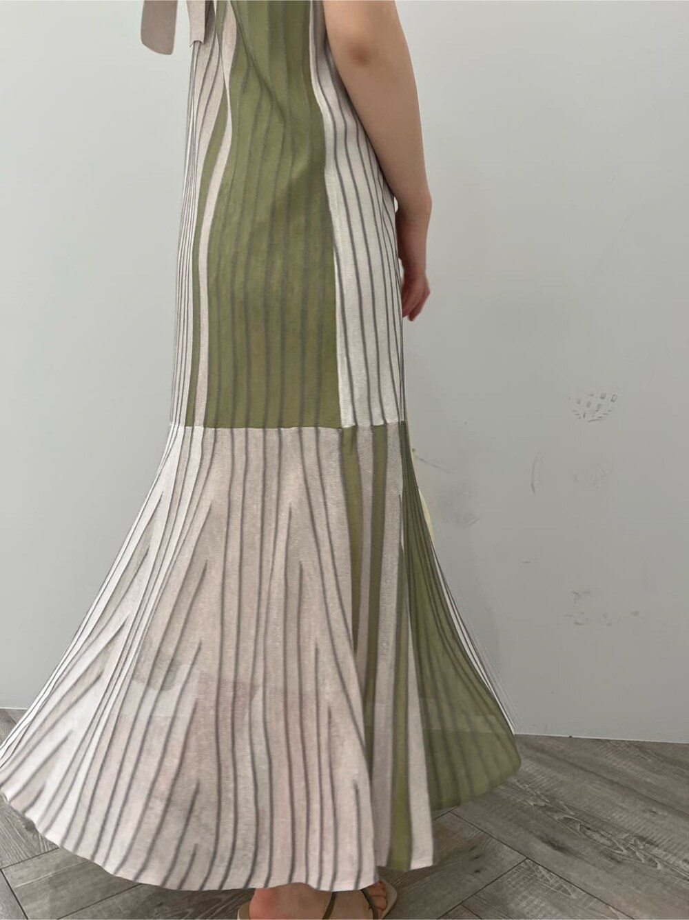 グリーン系のワンピース、グリーン系のサンダル、ゴールド系のピアス（両耳用）を着用したレディースの夏コーディネートの7枚目の写真