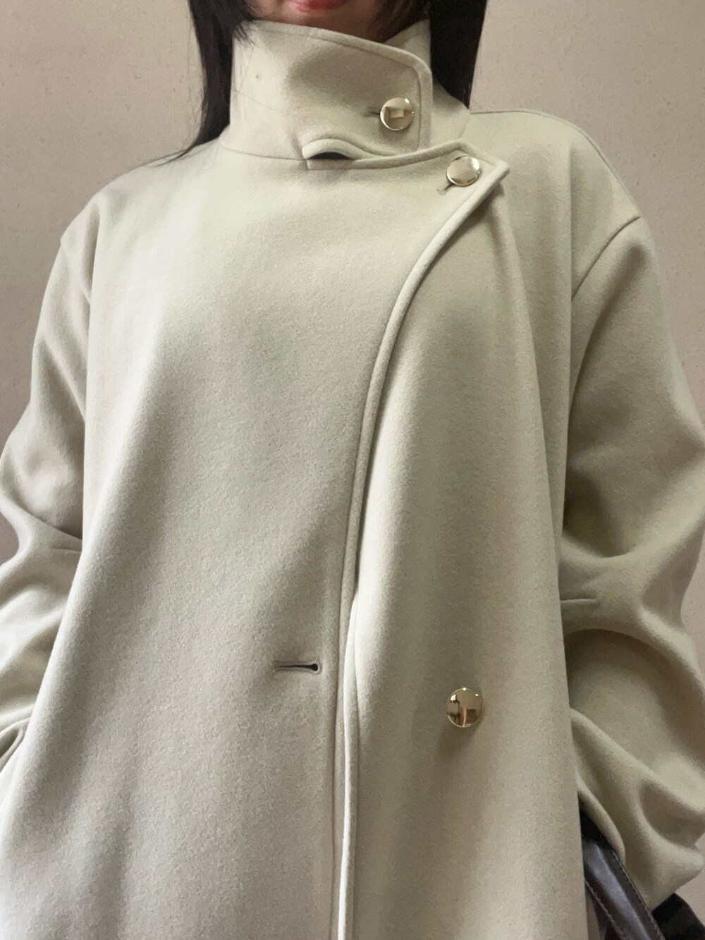 グリーン系のチェスターコート、ブラウン系のハンドバッグ、ブラウン系のその他パンツを着用したレディースの秋コーディネートの4枚目の写真