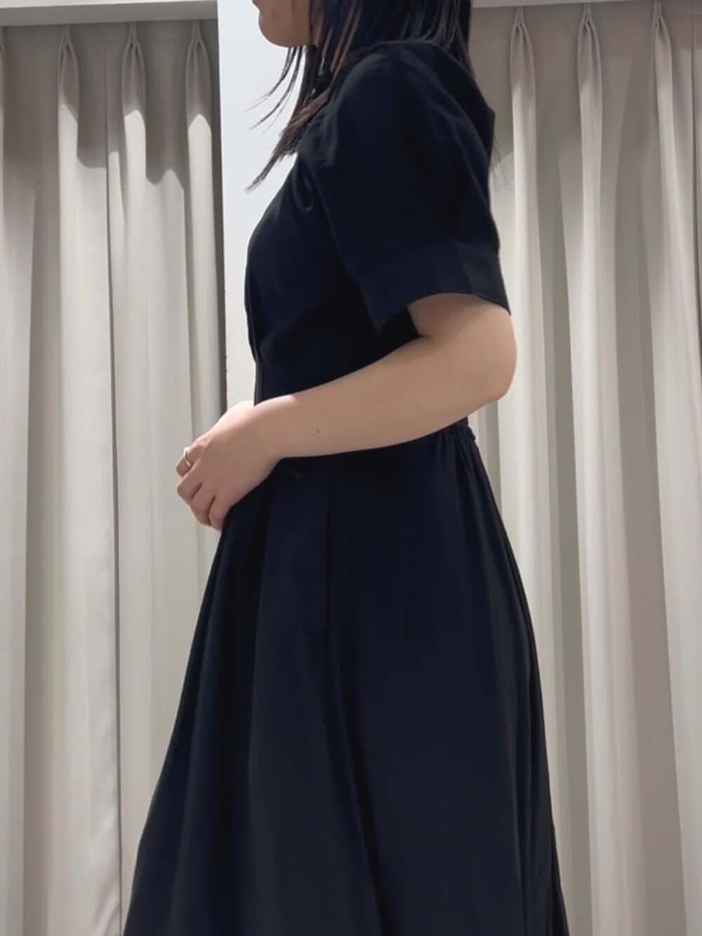 ホワイト系のサンダル、ブラック系のワンピースを着用したレディースの春コーディネートの5枚目の写真