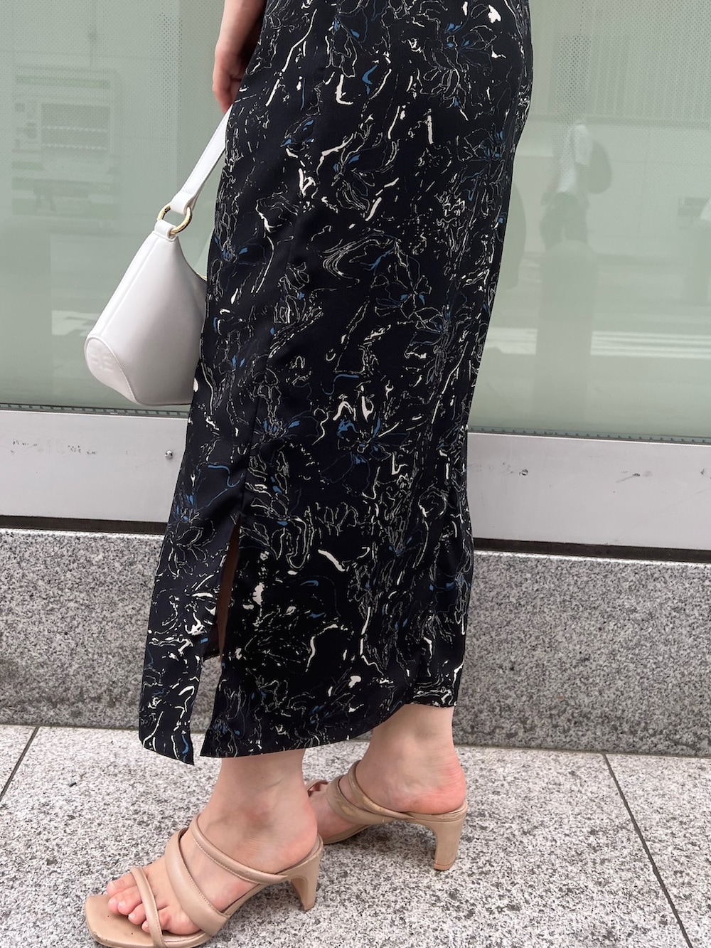 ベージュ系のサンダル、ホワイト系のハンドバッグ、ブラック系のワンピースを着用したレディースの夏コーディネートの8枚目の写真