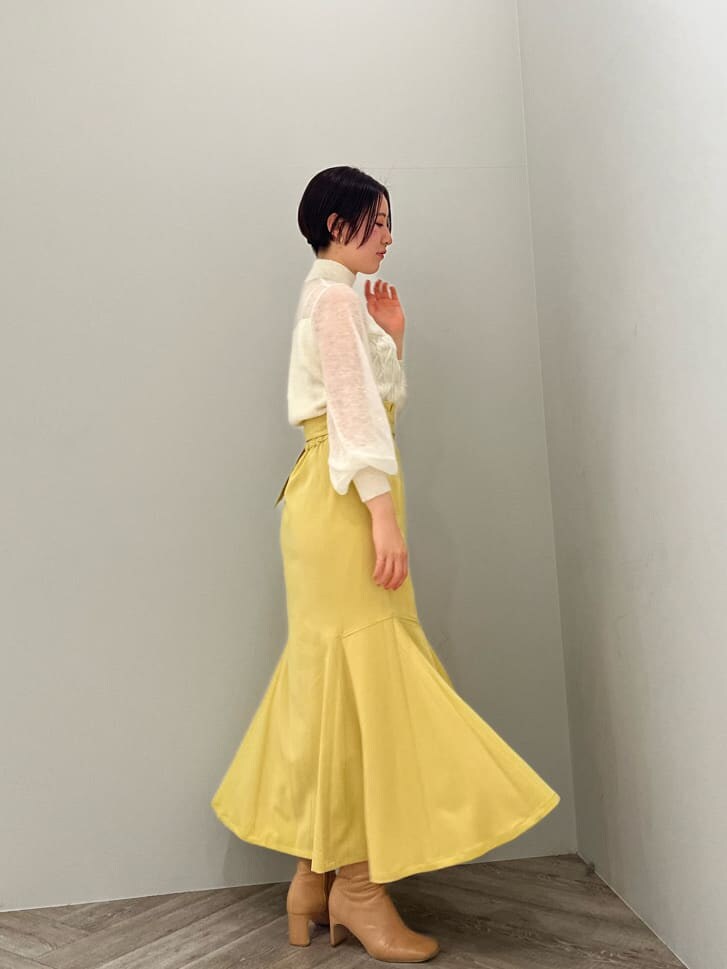 ベージュ系のその他シューズ、ホワイト系のニット/セーター、イエロー系のスカートを着用したレディースの冬コーディネートの2枚目の写真