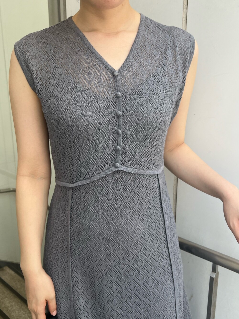 ブラック系のショルダーバッグ、グレー系のワンピースを着用したレディースの夏コーディネートの3枚目の写真