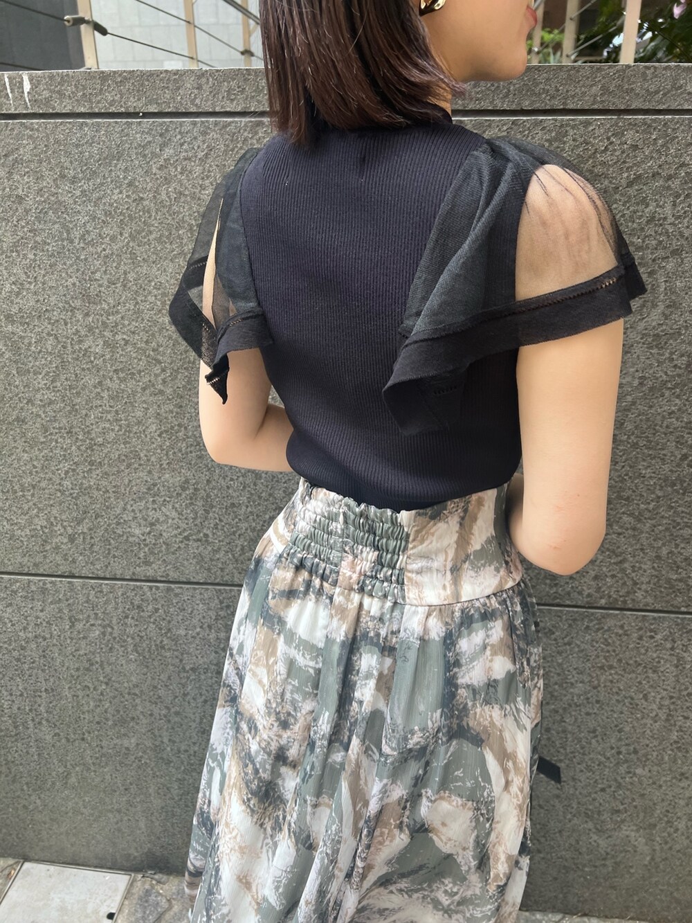 ブラック系のニット/セーター、グレー系のスカート、ブラック系のショルダーバッグを着用したレディースの春コーディネートの6枚目の写真