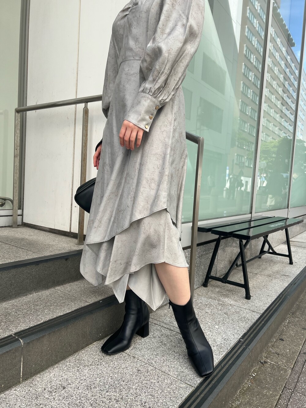 グレー系のカーディガン/ボレロ、グレー系のワンピース、ブラック系のブーツを着用したレディースの秋コーディネートの6枚目の写真