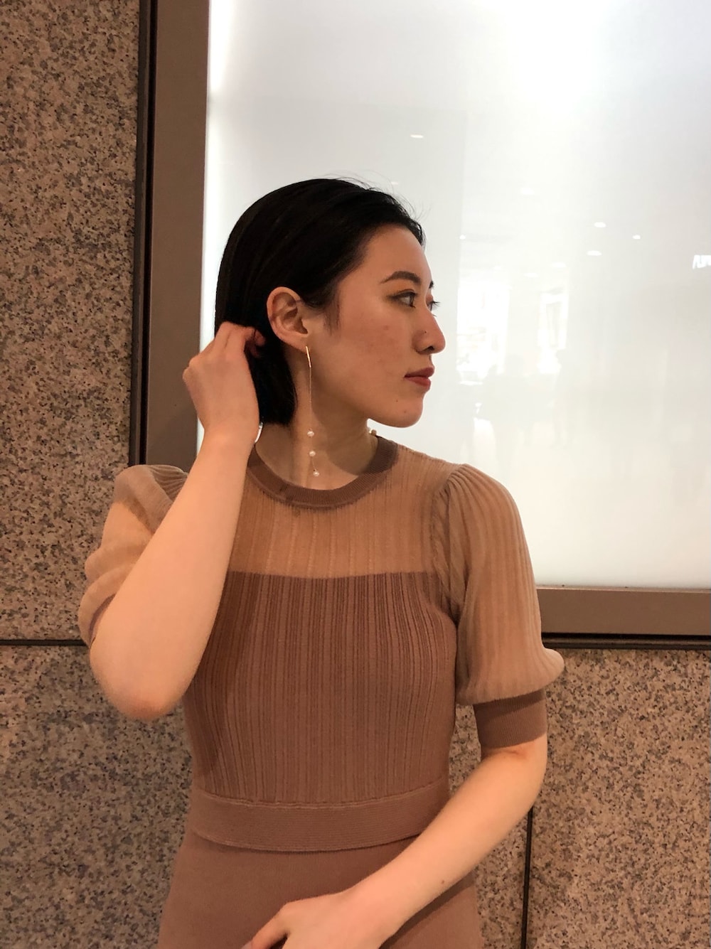 ベージュ系のワンピース、ホワイト系のピアス（両耳用）を着用したレディースの春コーディネートの5枚目の写真