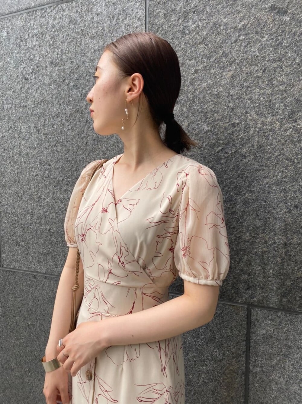 ブラウン系のパンプス、ベージュ系のショルダーバッグ、ホワイト系のワンピースを着用したレディースの夏コーディネートの6枚目の写真