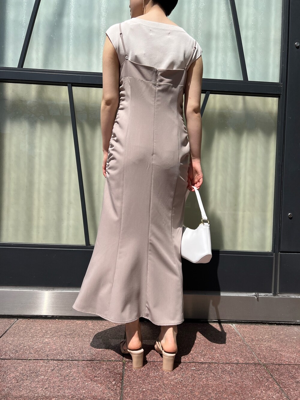 ベージュ系のワンピース、ピンク系のテーラードジャケット、ホワイト系のハンドバッグを着用したレディースの春コーディネートの8枚目の写真