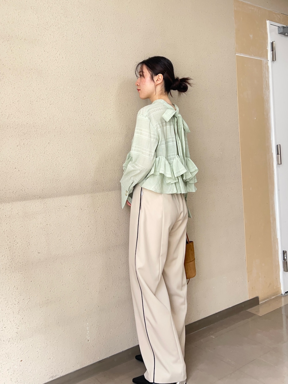 ベージュ系のその他パンツ、グリーン系のシャツ/ブラウス、ブラック系のパンプスを着用したレディースの春コーディネートの2枚目の写真