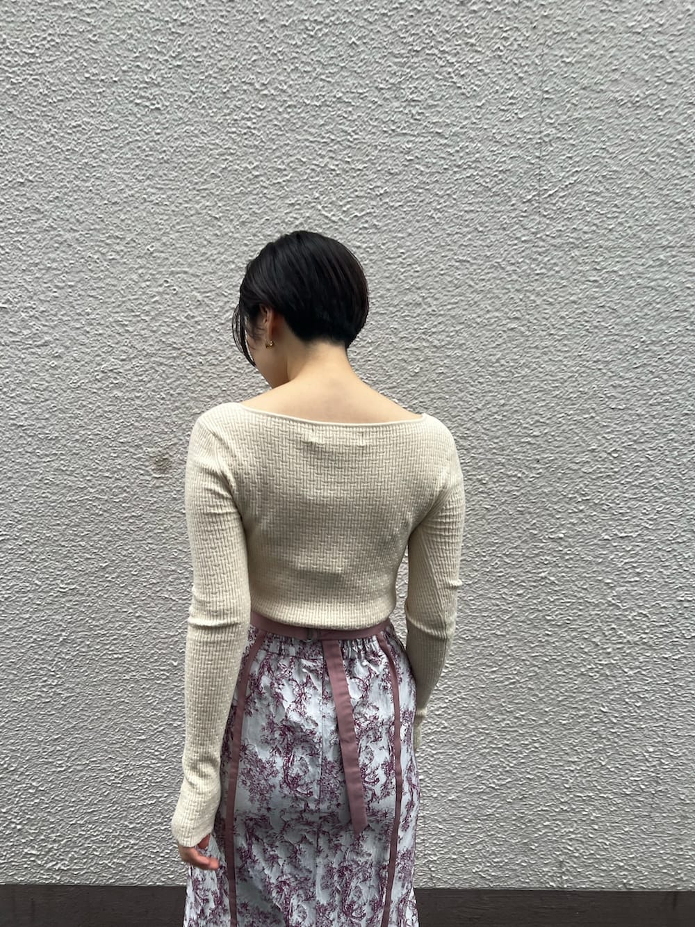 ベージュ系のブーツ、ベージュ系のその他アウター、ホワイト系のニット/セーターを着用したレディースの秋コーディネートの7枚目の写真