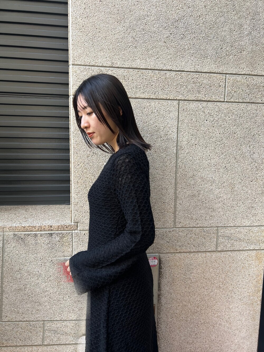 ブラック系のブーツ、ブラック系のワンピース、ホワイト系のショルダーバッグを着用したレディースの秋コーディネートの4枚目の写真