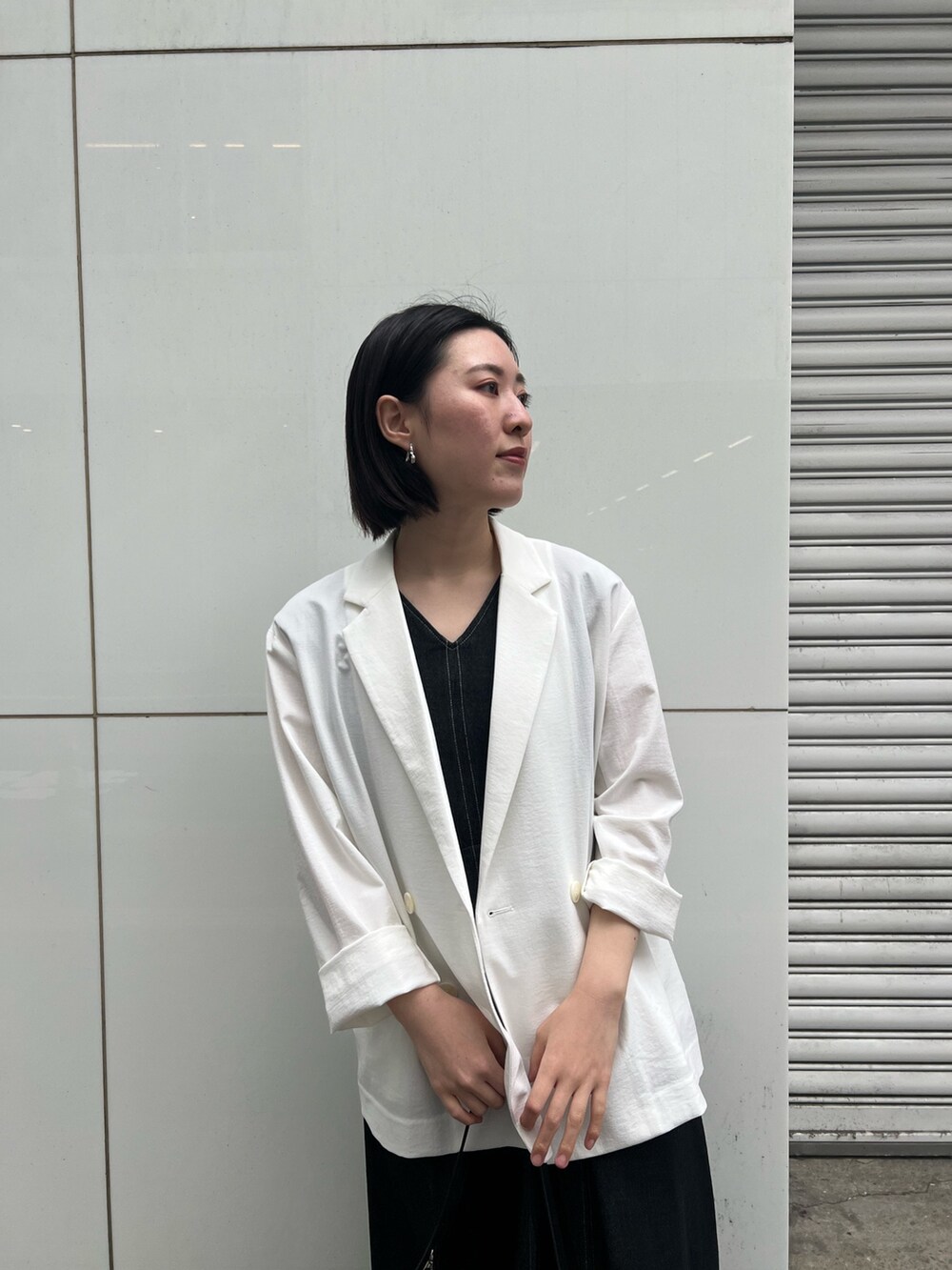 ブラック系のワンピース、ブラック系のサンダル、ブラック系のハンドバッグを着用したレディースの春コーディネートの2枚目の写真