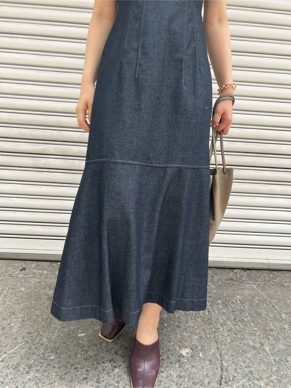 ベージュ系のハンドバッグ、レッド系のサンダル、ブラック系のワンピースを着用したレディースの夏コーディネートの6枚目の写真