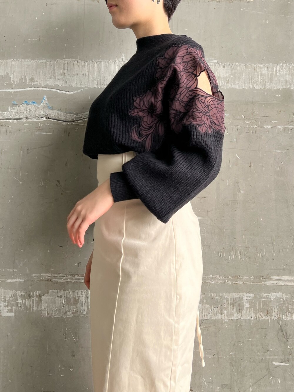 レッド系のブーツ、ホワイト系のスカート、ブラウン系のブルゾンを着用したレディースの冬コーディネートの6枚目の写真