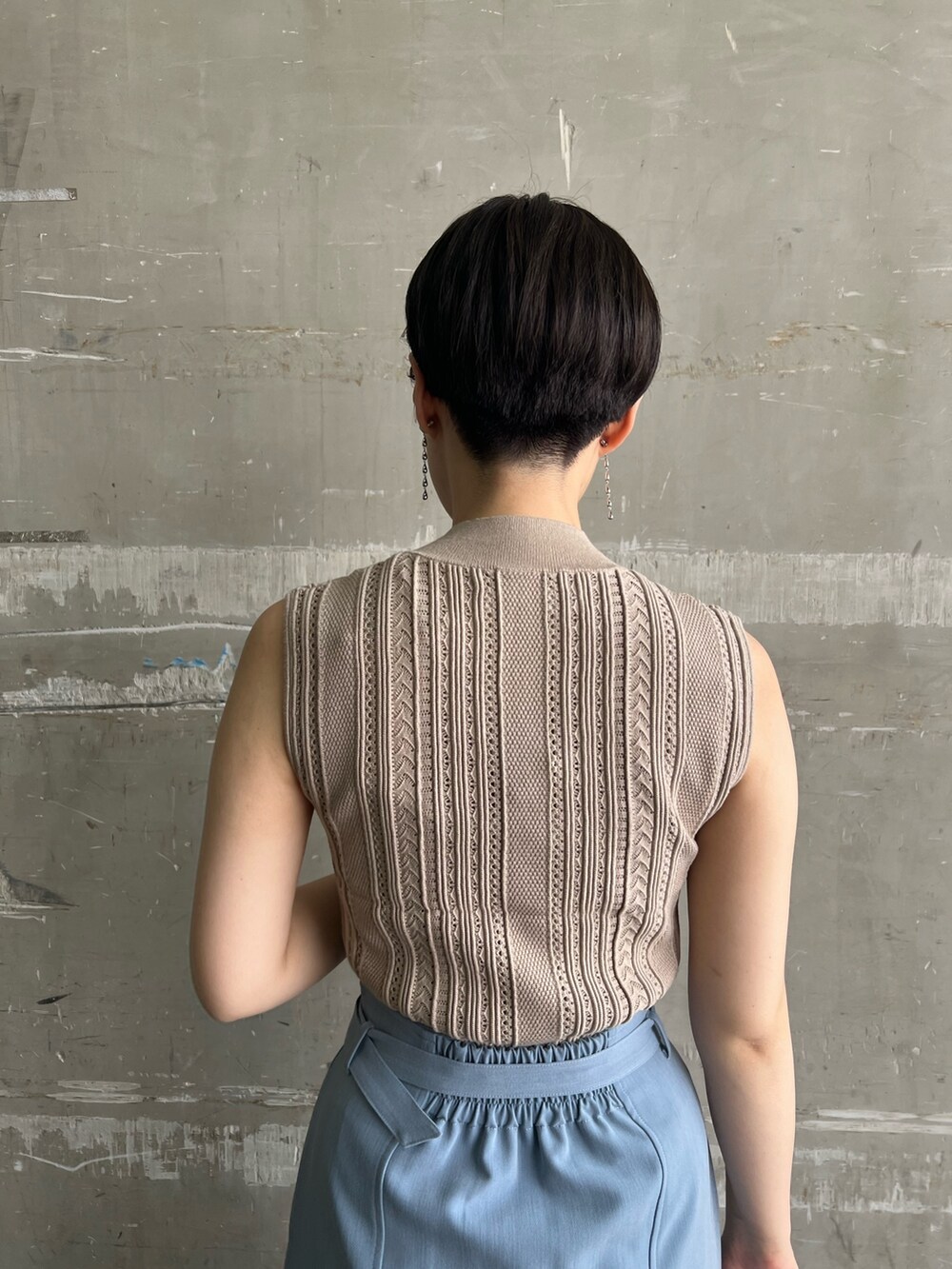 ベージュ系のニット/セーター、ブルー系のスカート、ベージュ系のサンダルを着用したレディースの夏コーディネートの5枚目の写真