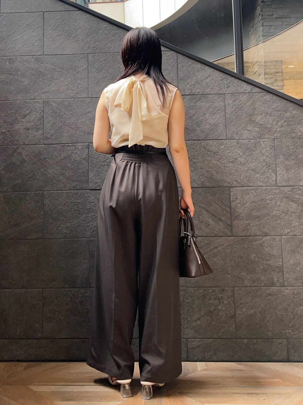 ホワイト系のシャツ/ブラウス、グレー系のその他パンツ、ブラウン系のボストンバッグを着用したレディースの夏コーディネートの3枚目の写真