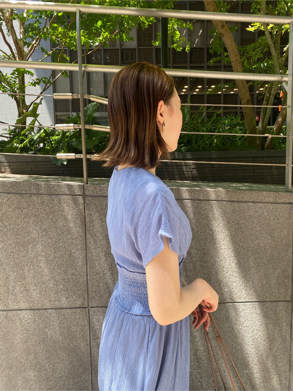 ブラック系のハンドバッグ、ブルー系のワンピース、ブラック系のその他シューズを着用したレディースの夏コーディネートの6枚目の写真