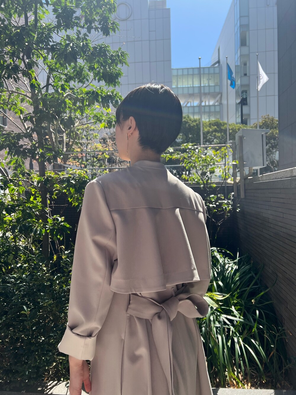 ホワイト系のハンドバッグ、ベージュ系のサンダル、ホワイト系のワンピースを着用したレディースの春コーディネートの4枚目の写真