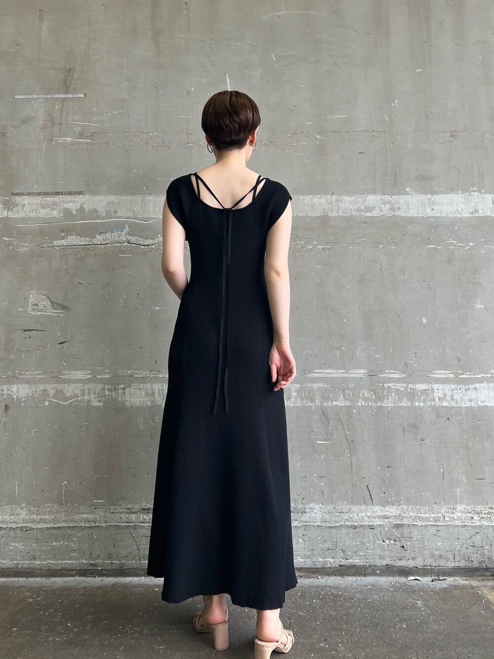 ブラック系のワンピース、ホワイト系のハンドバッグ、ベージュ系のサンダルを着用したレディースの夏コーディネートの3枚目の写真