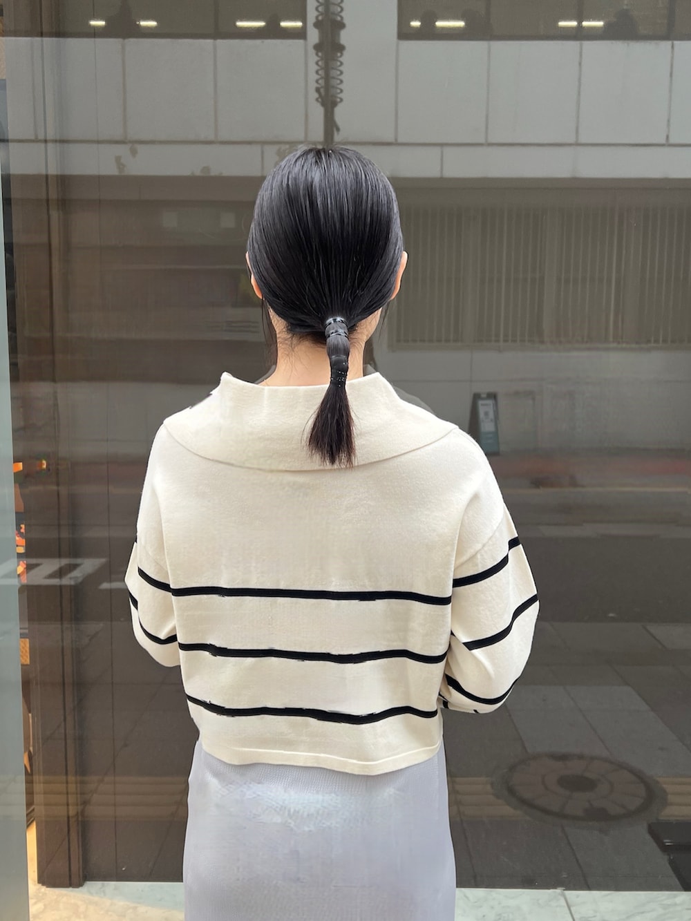 ホワイト系のニット/セーター、グレー系のスカートを着用したレディースの冬コーディネートの5枚目の写真