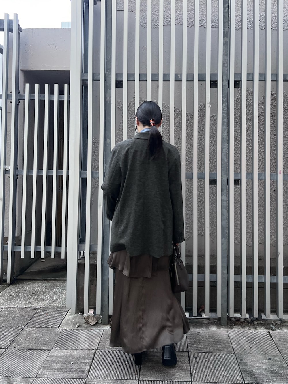 ブラック系のブーツ、ブルー系のニット/セーター、ブラウン系のテーラードジャケットを着用したレディースの秋コーディネートの3枚目の写真