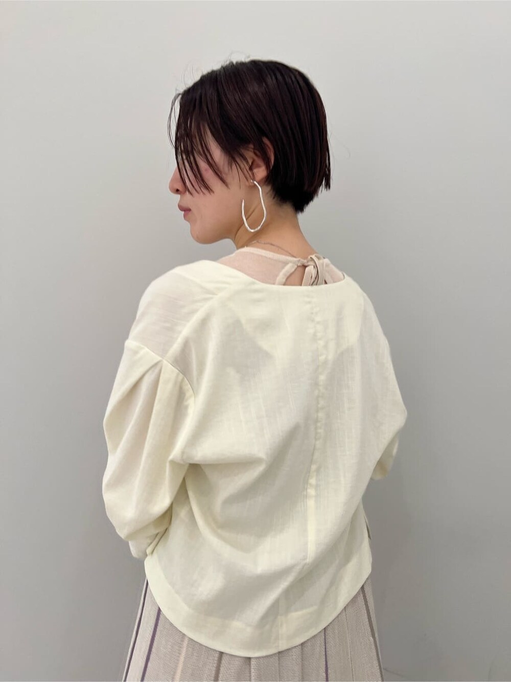 ホワイト系のノーカラージャケット、その他のパンプス、パープル系のワンピースを着用したレディースの夏コーディネートの6枚目の写真