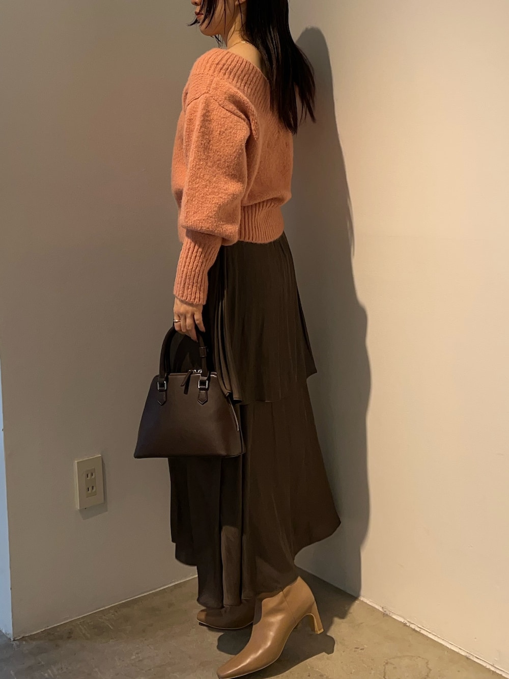 ピンク系のニット/セーター、ベージュ系のブーツ、ブラウン系のスカートを着用したレディースの秋コーディネートの2枚目の写真