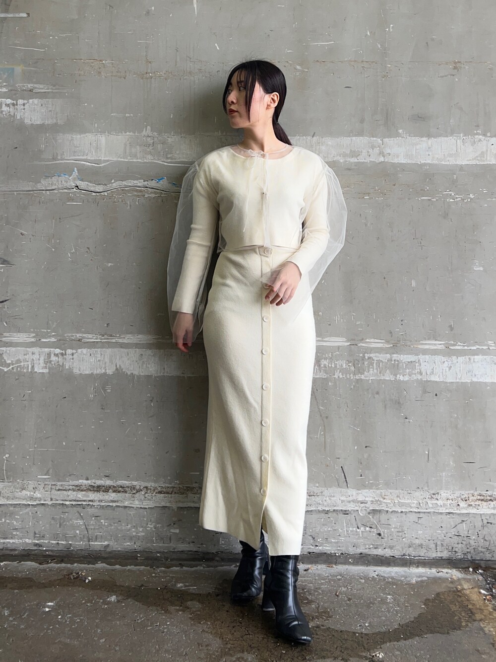 ホワイト系のブルゾン、ホワイト系のワンピース、ブラック系のブーツを着用したレディースの冬コーディネートの6枚目の写真