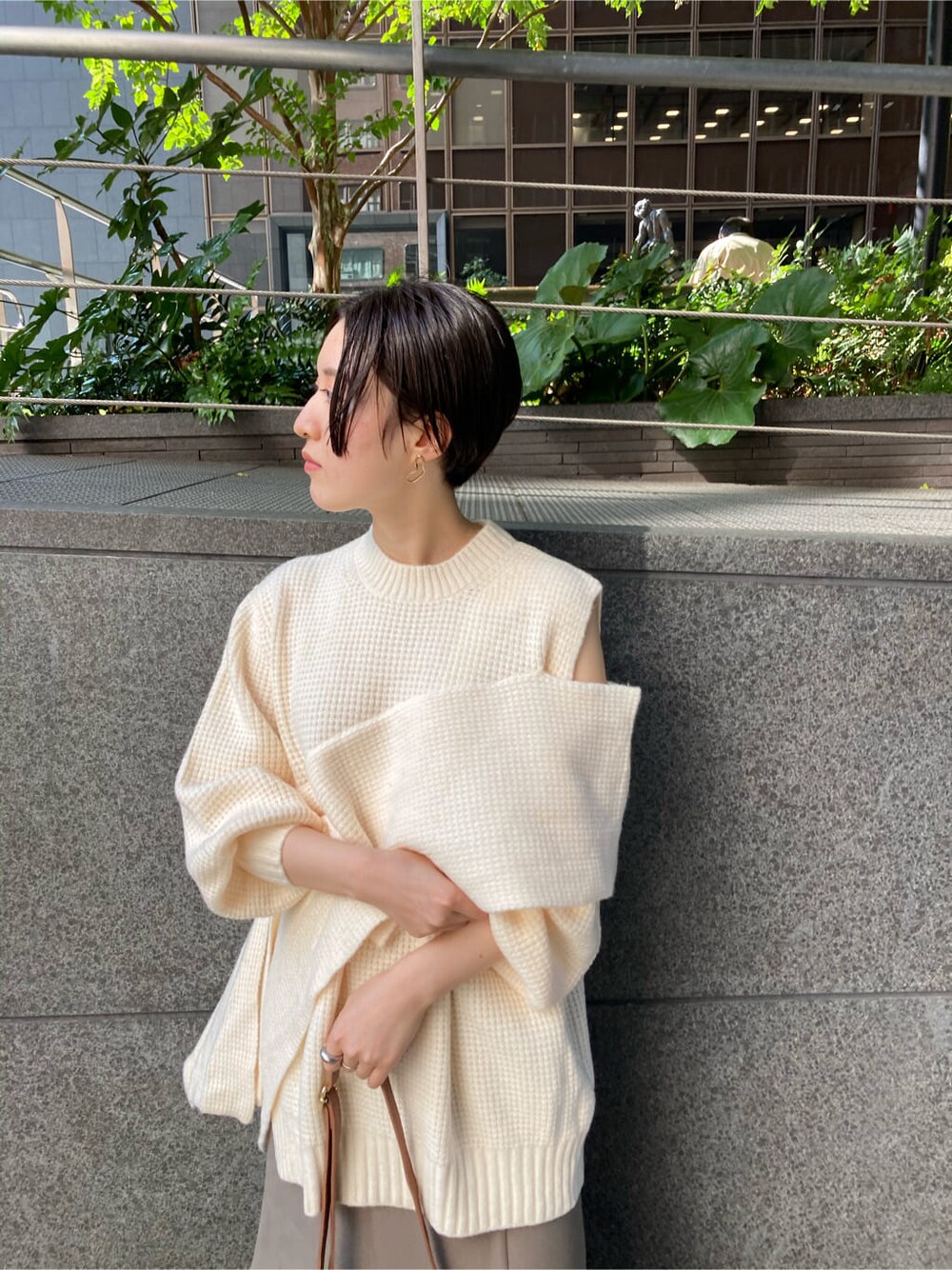 ベージュ系のスカート、ブラウン系のショルダーバッグ、ホワイト系のニット/セーターを着用したレディースの秋コーディネートの3枚目の写真