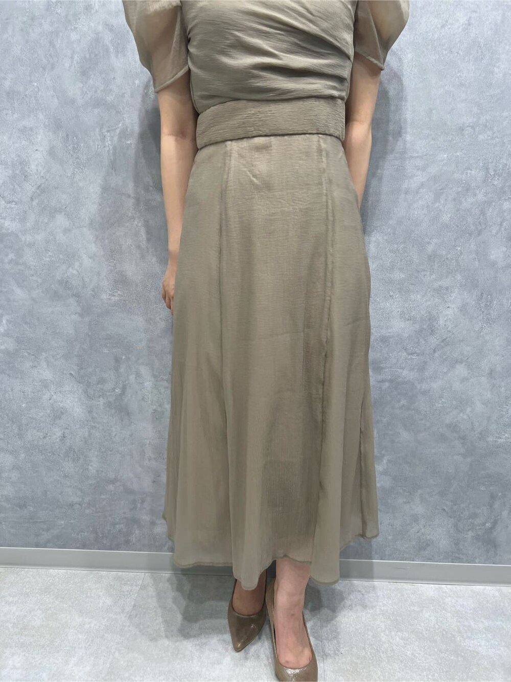 ベージュ系のドレス、ベージュ系のドレス、ゴールド系のパンプスを着用したレディースの秋コーディネートの7枚目の写真