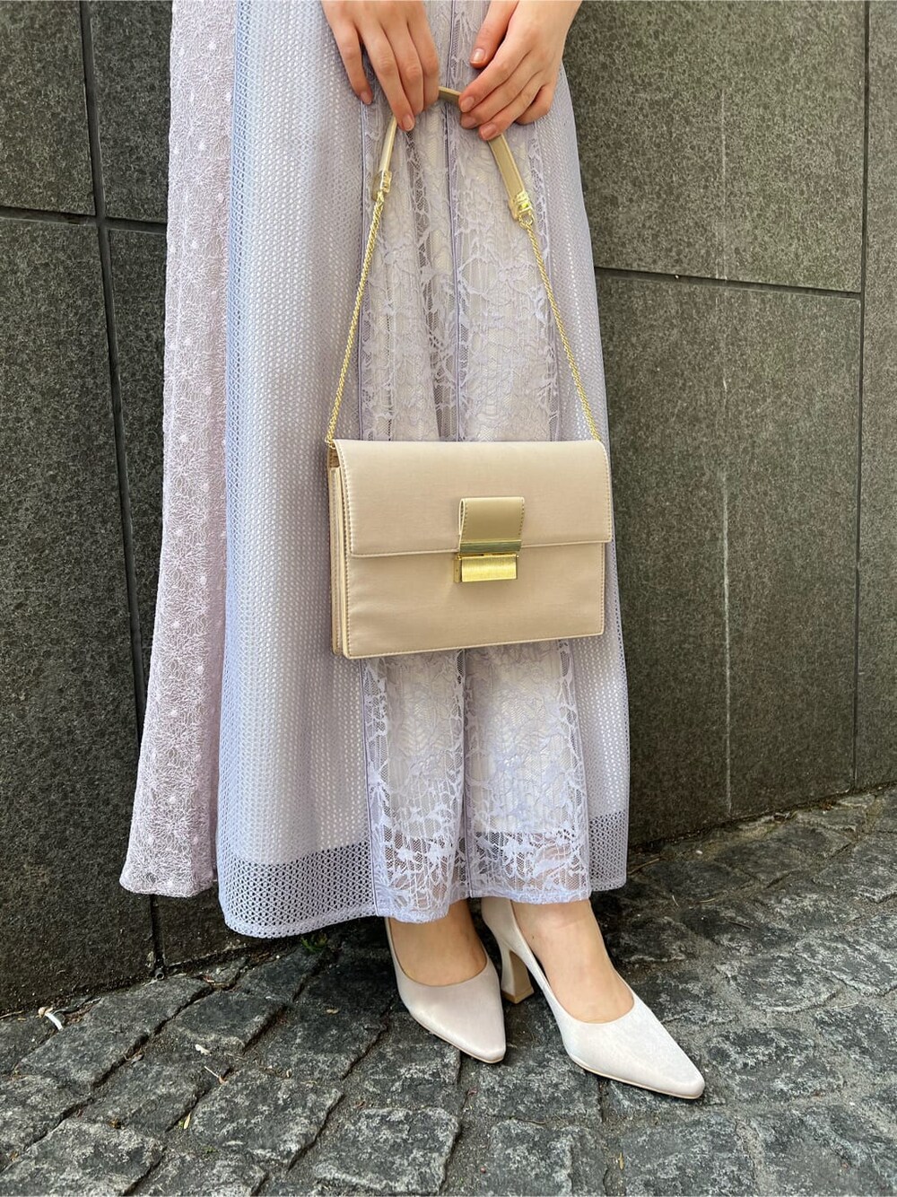 パープル系のドレス、ベージュ系のクラッチバッグ、ベージュ系のパンプスを着用したレディースの春コーディネートの7枚目の写真