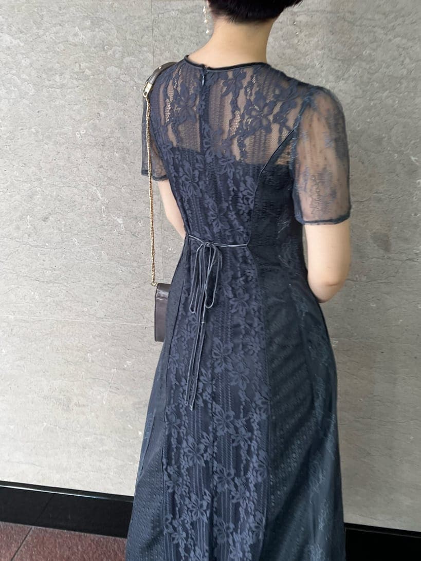 シルバー系のパンプス、グレー系のドレス、シルバー系のクラッチバッグを着用したレディースの冬コーディネートの4枚目の写真