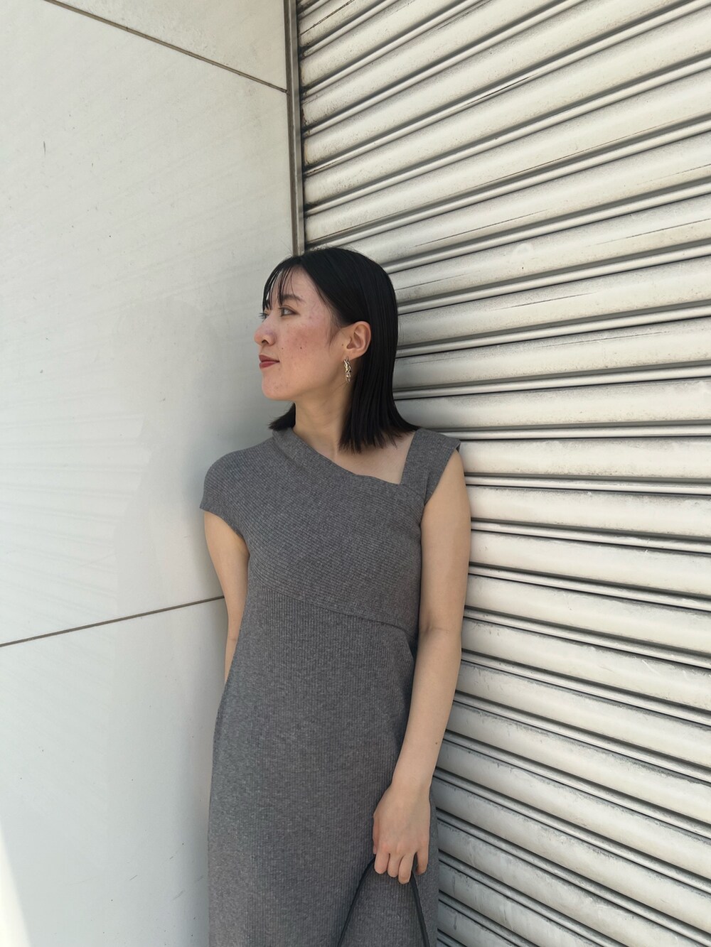 グレー系のワンピース、ブラック系のサンダル、ブラック系のショルダーバッグを着用したレディースの夏コーディネートの4枚目の写真