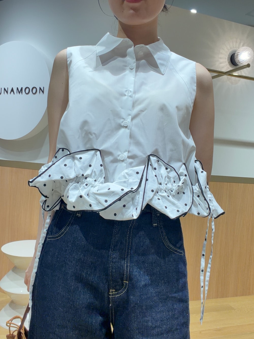 ブルー系のデニムパンツ、オレンジ系のサンダル、ホワイト系のシャツ/ブラウスを着用したレディースの夏コーディネートの4枚目の写真