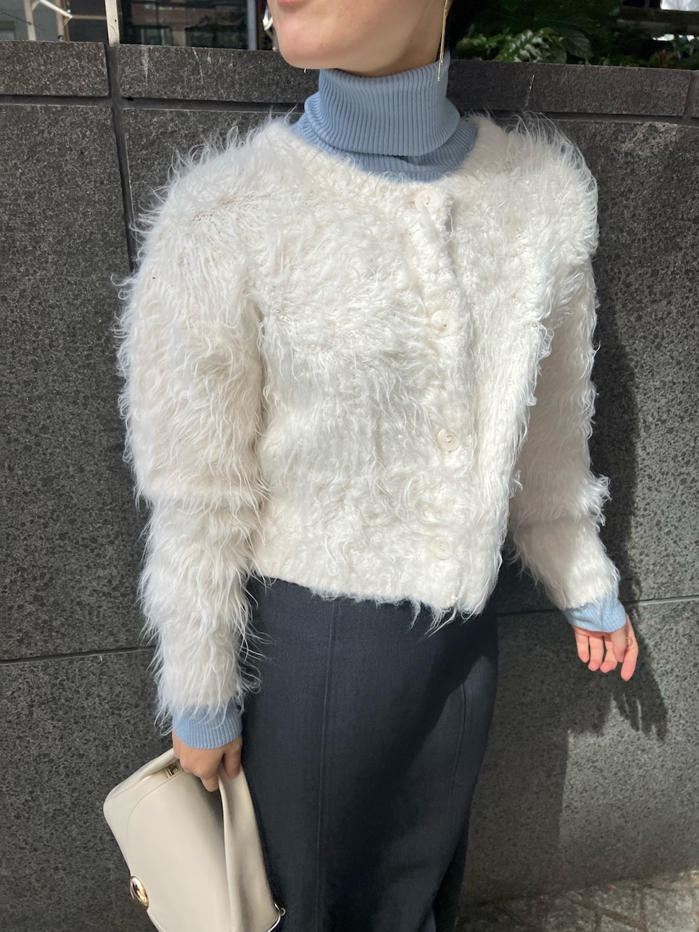 ホワイト系のブーツ、ホワイト系のカーディガン/ボレロ、ブルー系のニット/セーターを着用したレディースの秋コーディネートの3枚目の写真